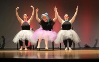danceability 2022 Recital three dancers wearing tutus on stage